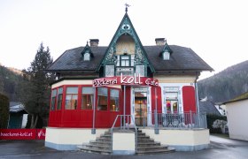 Fachgeschäft mit Café in Scheiblingkirchen, © Koll GmbH Bäckerei Koll Café in einem historischen Gebäude mit roter Fassade und dekorativem Giebel.