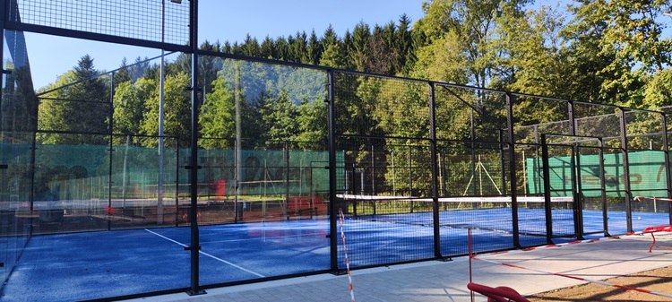 Padeltennis Bad Schönau, © Wiener Alpen Padeltennisplatz in Bad Schönau mit blauem Boden und umliegendem Wald.