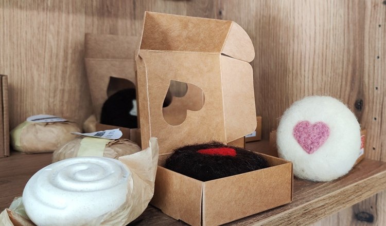 mobiler Hofladen mit liebevollen Produkten, © Wiener Alpen Handgemachte Seifen und Deko mit Herzmotiven in einem Regal.