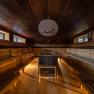 Hotel & Spa Linsberg Asia, © Niederösterreich Werbung / Maximilian Pawlikowsky Innenansicht einer geräumigen Sauna mit Holzbänken und einem Ofen in der Mitte.
