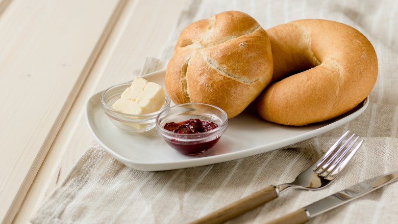 Frühstück genießen., © Koll GmbH Frühstücksteller mit Brötchen, Butter und Marmelade auf einem Tisch.