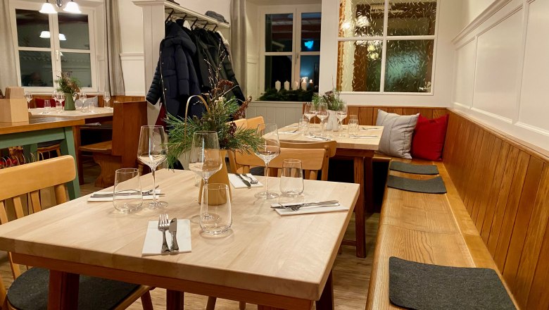 s'Hutwisch Gaststube, © Hutwisch Regionalentwicklung eGen Die Gaststube mit Holzbank, Holztischen und Garderobe.