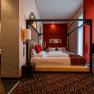 Hotel & Spa Linsberg Asia, © Niederösterreich Werbung / Maximilian Pawlikowsky Hotelzimmer mit Himmelbett, roten Akzenten und asiatischem Dekor.