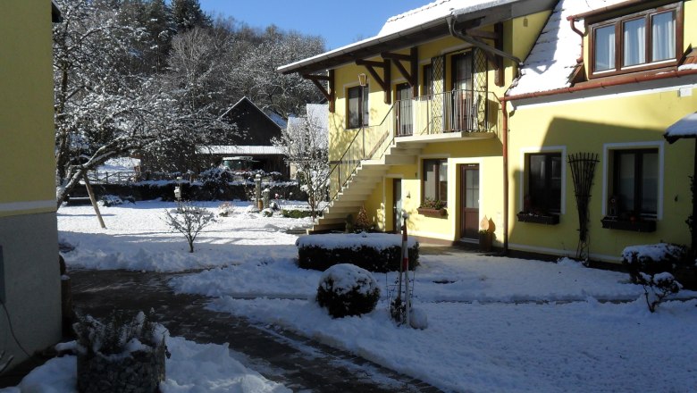 Pension Hendling im Winter, © Josef Hendling Gelbes Gebäude im Schnee mit blauem Himmel.