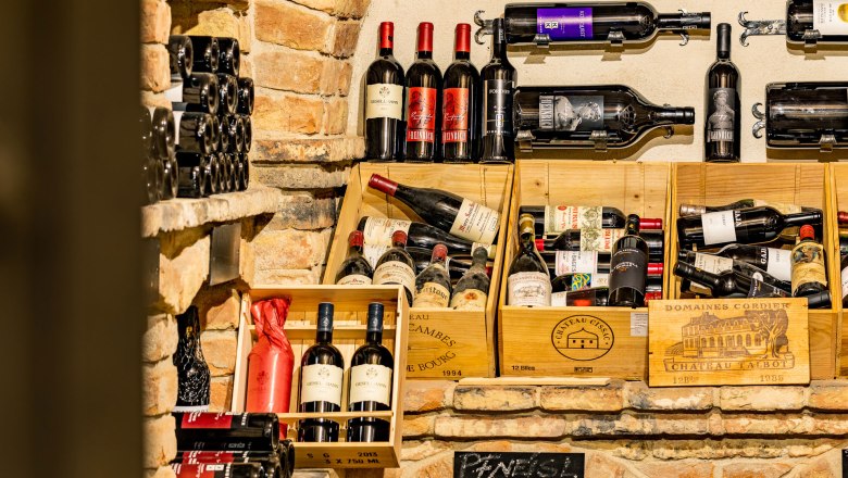 Weinkeller, © Christian Kremsl Weinflaschen in einem rustikalen Weinkeller mit Backsteinwänden.