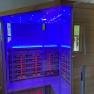 Infrarotkabine im Badezimmer integriert, © Wiener Alpen Infrarotkabine mit blauer Beleuchtung in einem Badezimmer.