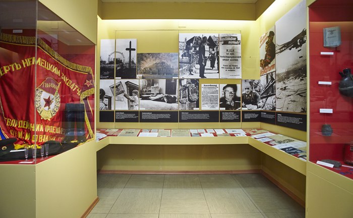 Gedenkraum 1945 in Hochwolkersdorf, © Wiener Alpen, Foto: Bene Croy Ausstellungsraum mit historischen Fotos, Dokumenten und einer roten Fahne.