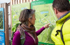 Wanderstartplatz Bad Schönau, © Wiener Alpen/Florian Lierzer Zwei Personen betrachten eine Wanderkarte von Bad Schönau.