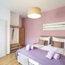 Zimmer Rosé, Gästezimmer Victoria, © Marianne Graf Ein gemütliches Gästezimmer mit rosa Wand, Doppelbett und moderner Einrichtung.