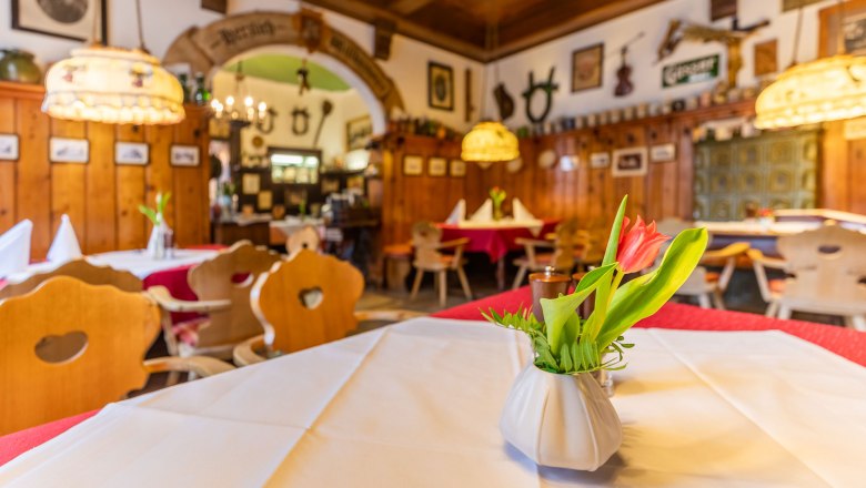 Gastzimmer, © Christian Kremsl Gemütliches Gastzimmer mit Holzmöbeln, Tischdecken und Blumenvasen.