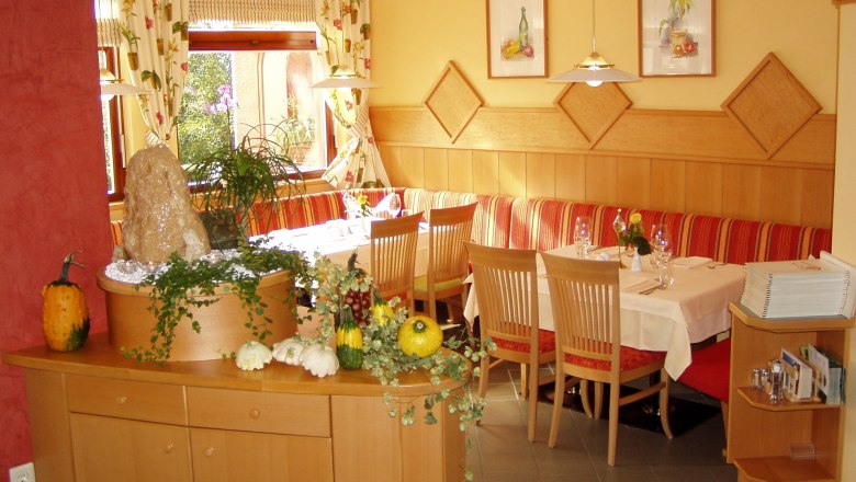 Restaurant, © Karl Görg Gemütliches Restaurant mit Holzmöbeln, dekoriert mit Kürbissen und Pflanzen.