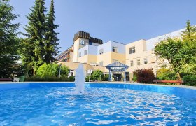 Das Gesundheitsresort Königsberg von außen, © Gesundheitsresort Königsberg Eingangsbereich des Gesundheitsresorts Königsberg mit Springbrunnen und Bäumen.