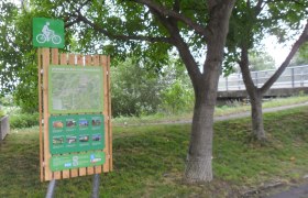Radstartplatz-Tafel Lanzenkirchen, © ©Wiener Alpen Radstartplatz-Tafel in Lanzenkirchen mit Karte und Informationen, umgeben von Bäumen.