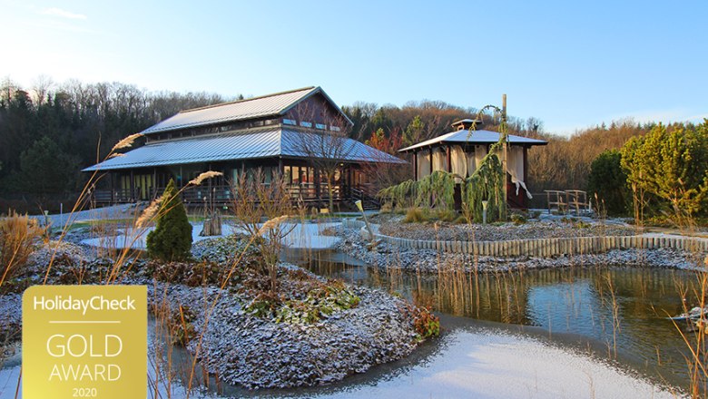 Asiatisch inspiriertes Gebäude mit Teich und Winterlandschaft.