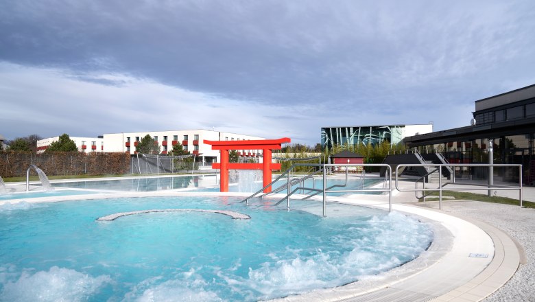 Außenbereich der Therme Linsberg Asia mit Pool und rotem Torii.