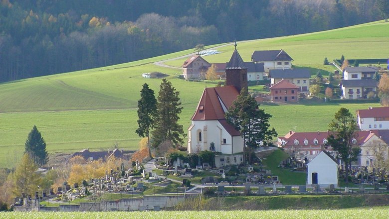 Erasmuskirche in Krumbach mit umliegendem Friedhof und grüner Landschaft.