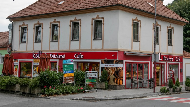 Ein zweistöckiges Gebäude mit einem Café und Bäckerei im Erdgeschoss in Pitten.