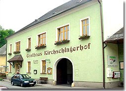 Ein traditionelles Gasthaus mit gr&uuml;ner Fassade und der Aufschrift 'Gasthaus Kirschlagerhof'.