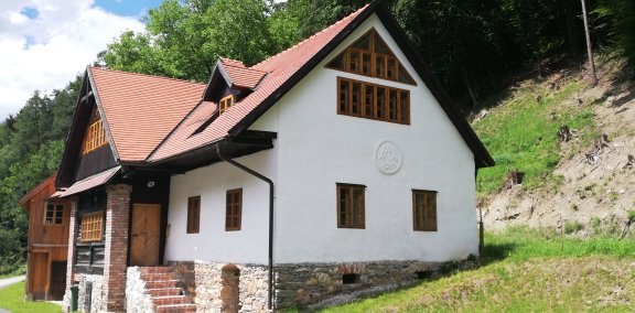 Traditionelles Haus mit rotem Dach in l&auml;ndlicher Umgebung.