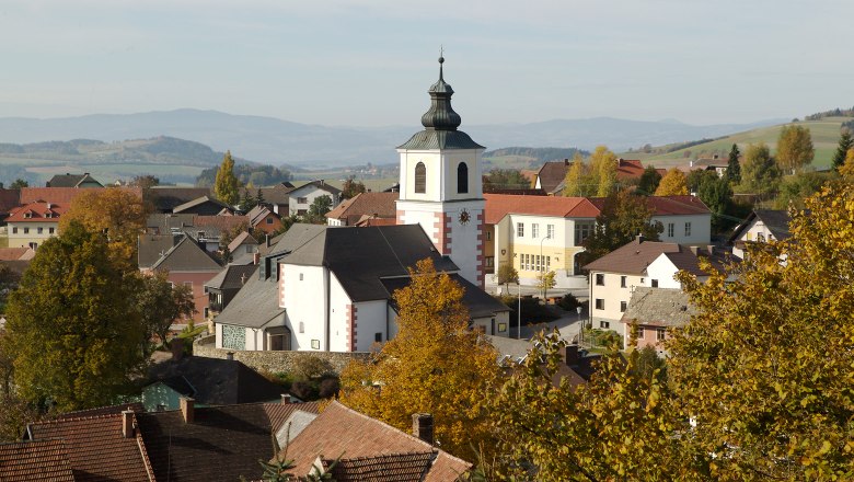 Panorama von Hochneukirchen-Gschaidt mit Kirche und umliegenden Häusern im Herbst.