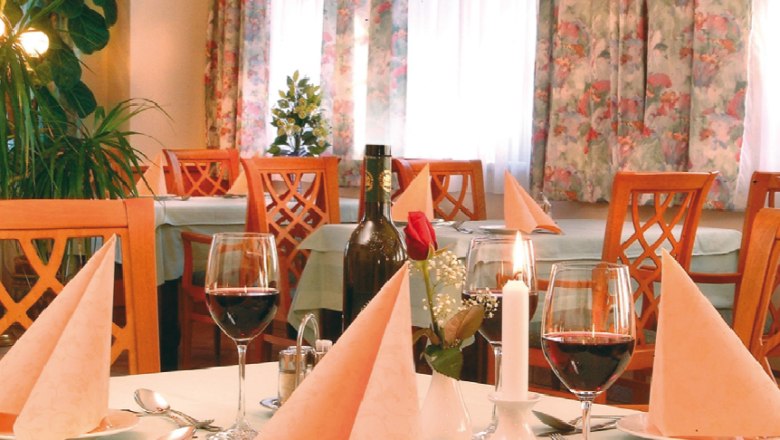 Elegantes Restaurant mit gedecktem Tisch, Weingläsern und Kerzen.