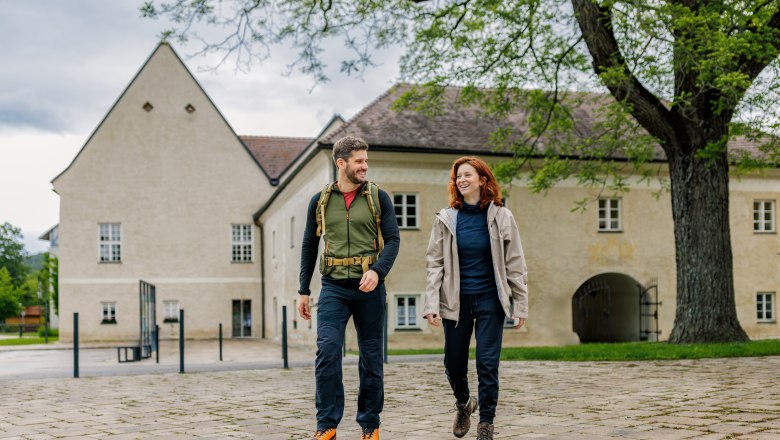 Zwei Wandernde vor dem historischen Schloss Katzelsdorf