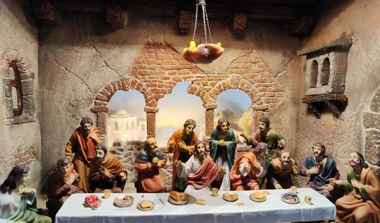 Passionskrippe mit Figuren beim letzten Abendmahl in einem rustikalen Raum.