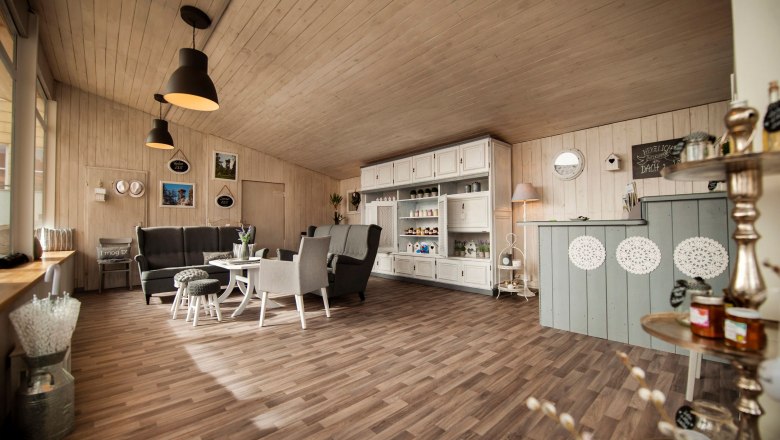 Innenansicht eines gem&uuml;tlichen Regionalladens mit Holzm&ouml;beln und Dekorationen.