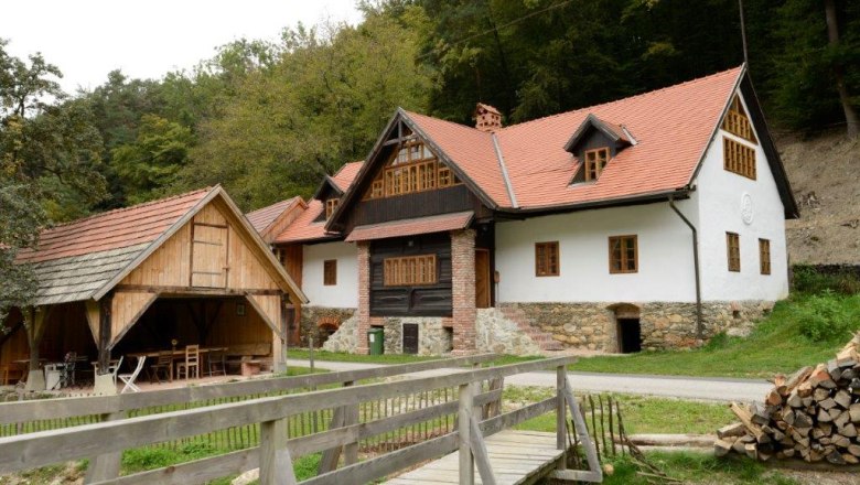 Traditionelles Haus mit rotem Dach und Holzdetails in l&auml;ndlicher Umgebung.