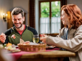 Beim Heurigen in Katzelsdorf, © Zwei Wanderer auf einer Holzbrücke im Wald