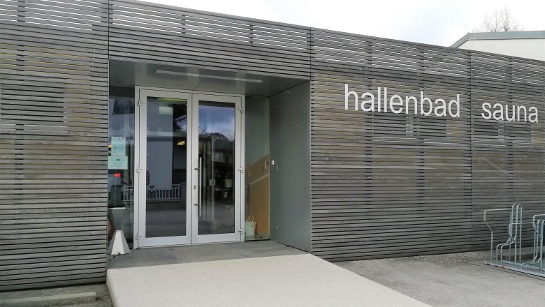 Eingang des Hallenbads mit Sauna in Scheiblingkirchen mit Holzvertäfelung und der Aufschrift "hallenbad sauna"