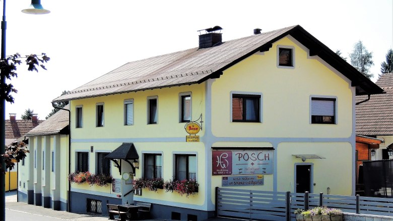 Gelbes Gasthaus mit Blumenk&auml;sten und Schild 'Posch'.