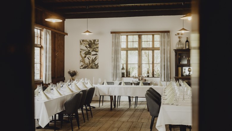 Elegantes Restaurant mit gedeckten Tischen und Holzboden.