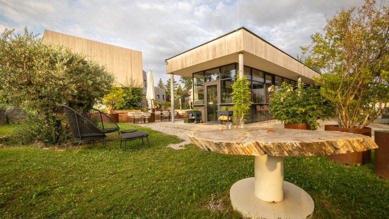 Gartenbereich eines modernen Hotels mit Sitzgelegenheiten und Pflanzen.