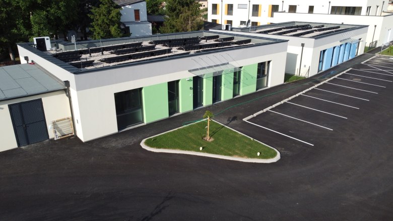 Außenansicht Ferienbungalows Vital, © Peter Hecht Außenansicht von modernen Ferienbungalows mit grünem und blauem Anstrich, Parkplatz und kleinem Rasenbereich.