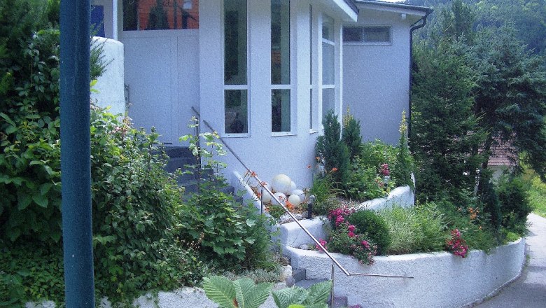 Eingang eines modernen Geb&auml;udes mit Garten und Treppe.