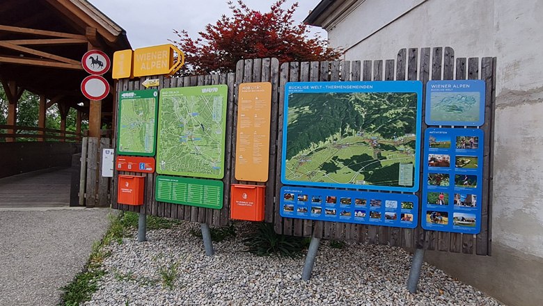 Wanderstartplatz in Bad Erlach mit großer Infotafel und Karten der Wiener Alpen.