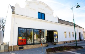 Ein wei&szlig;es Geb&auml;ude mit Schaufenstern