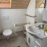 Modernes Badezimmer mit Dachfenster, Waschbecken, Toilette und Handtuchhalter.